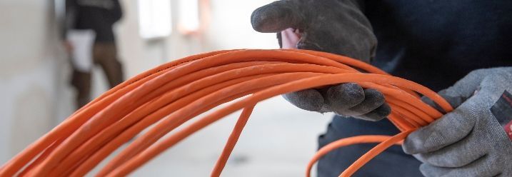 Person hält Netzwerkkabel in den Händen